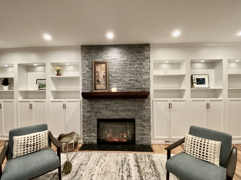 client living room with built-ins and natural stone fireplace feature