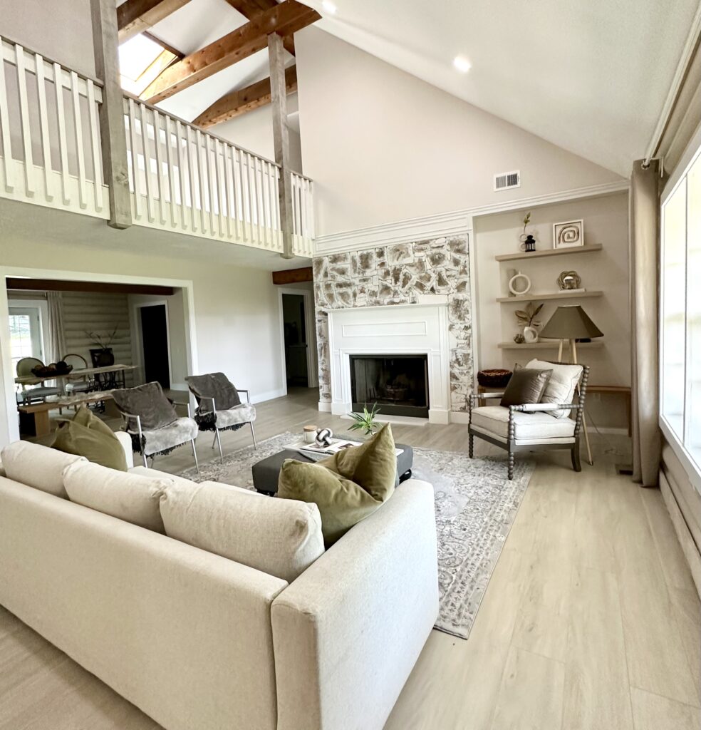 After remodeling photo of the living room featuring the white washed stone fireplace and modern neutral color furniture.