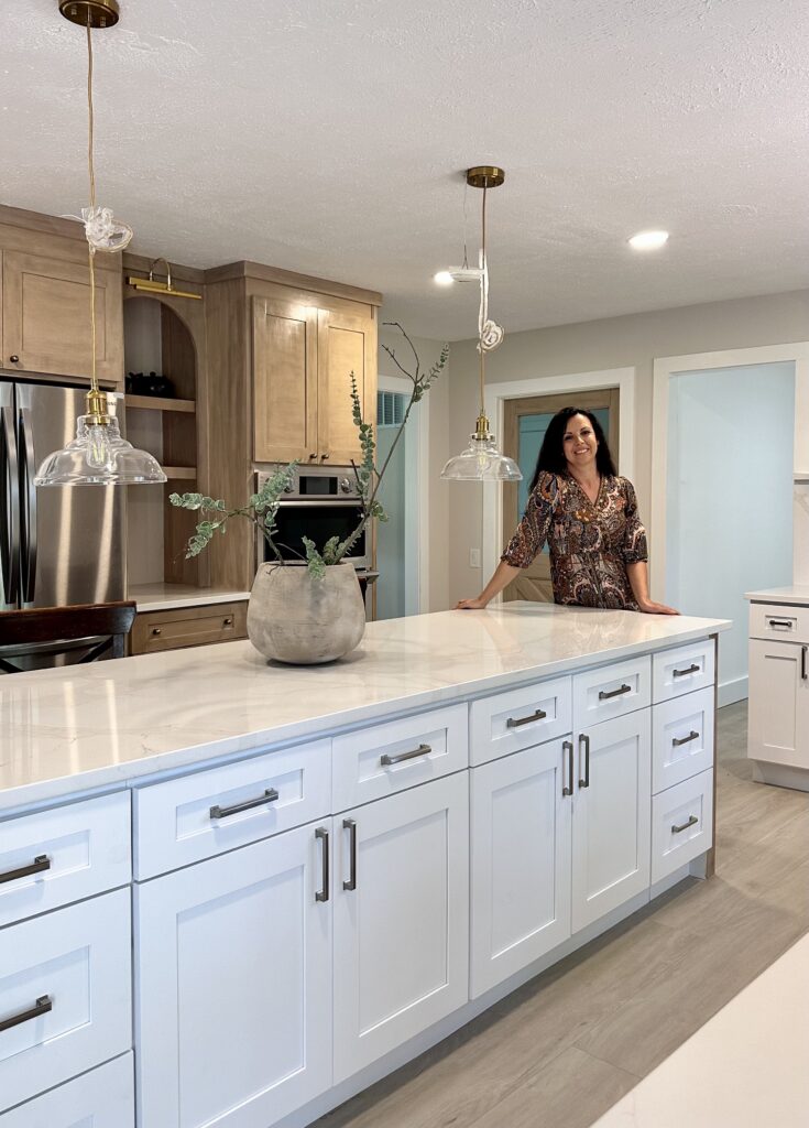 Updated kitchen with large white kitchen island with white marble countertop.